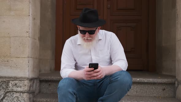 Man Suffering From Albinism Sits Outside and Surf the Internet alt