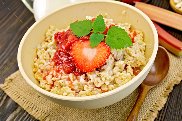 Oatmeal with strawberry-rhubarb sauce on board - Stock Photo - Images