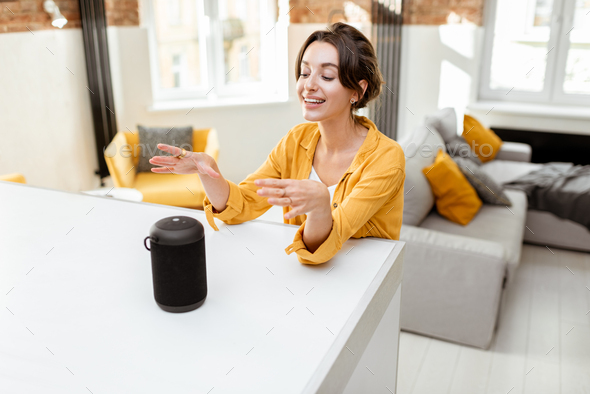 Woman controlling smart home devices with a voice commands