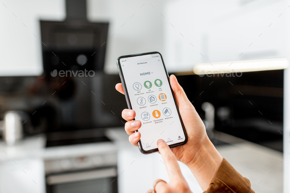 Controlling kitchen appliances with a smart phone Stock Photo by RossHelen