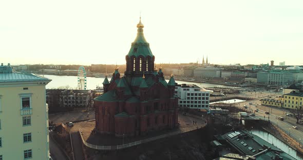 Aerial shot of a church in Helsinki during sunset. Slow orbit revealing sun behind. alt