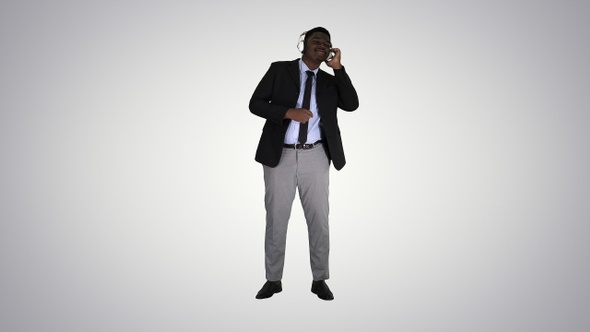 Black businessman dancing to music in headphones on gradient alt