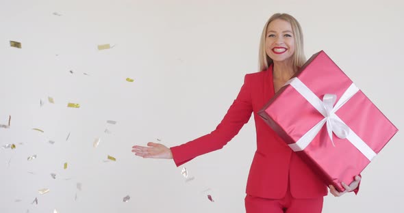 Gorgeous Woman in Red Suit with Christmas Gift.