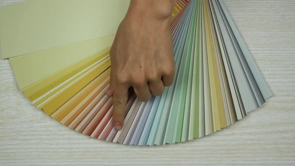 Finger pointing on one color in a palette of colours alt
