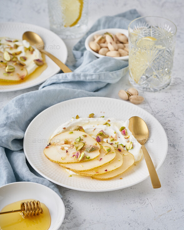 Ricotta with pears, pistachios and honey or maple syrup on white plate - Stock Photo - Images