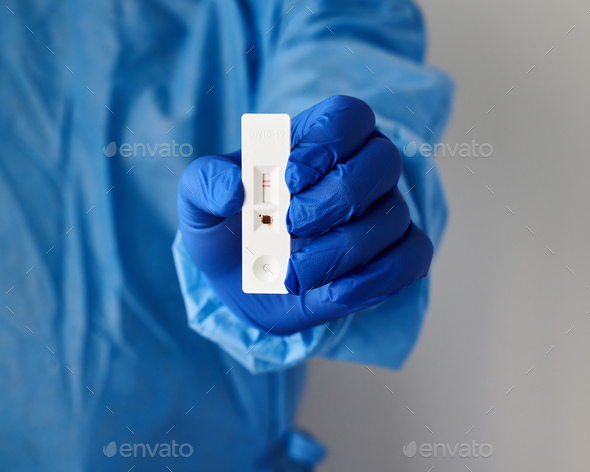 Unrecognizable doctor holds in hand positive test for antibodies to covid-19 virus - Stock Photo - Images