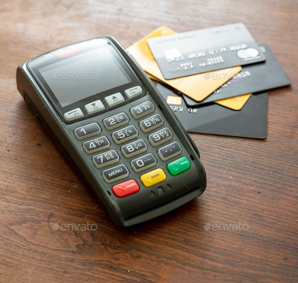 Payment machine, POS terminal and credit cards on wooden desk