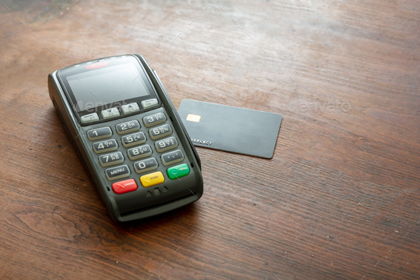 Payment machine, POS terminal and credit card on wooden desk