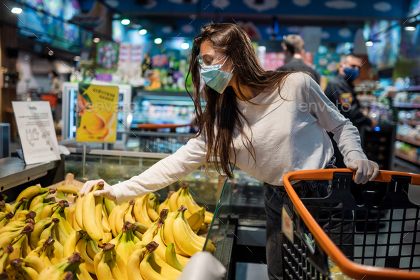 The girl with surgical mask is going to buy bananas - Stock Photo - Images