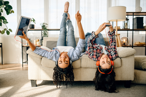 Happy women enjoys listening to music upside down - Stock Photo - Images