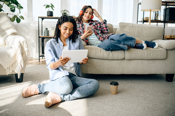 Two women enjoys listening to music indoors - Stock Photo - Images
