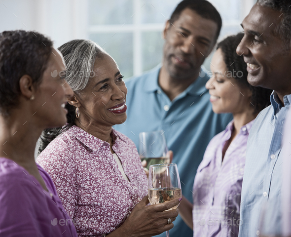 A group of African Americans of similar age, the baby boomer generation, having a party. Men and women.
