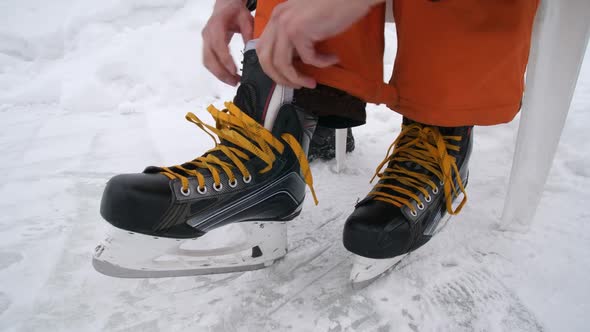 Men's Hands Tighten the Laces on Skates