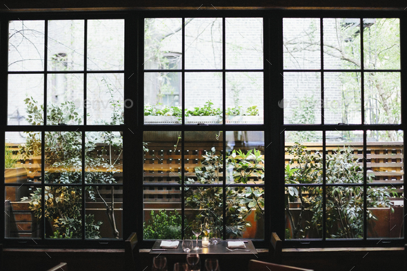 Interior view of a restaurant in Manhattan\'s West Village, window overlooking a garden.