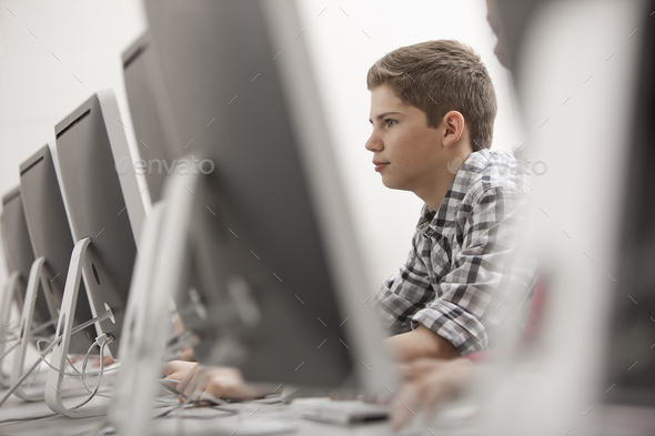 A computer laboratory, young person seated working at a terminal. Stock ...