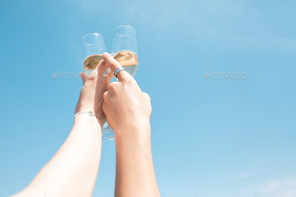 Seasonal feast at beach resort. Close up hands of friends celebrating, resting, having fun, clinking - Stock Photo - Images