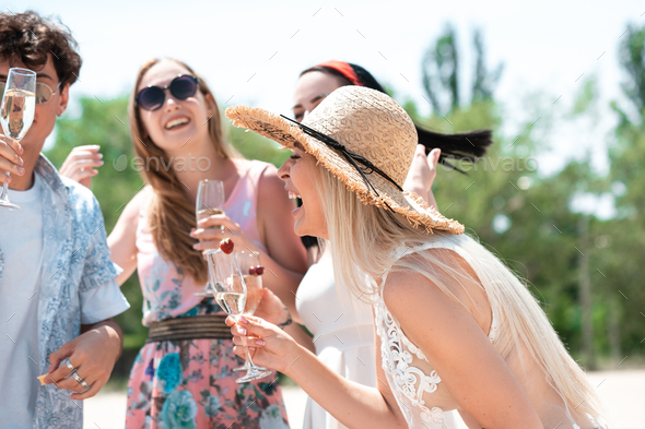 Seasonal feast at beach resort. Group of friends celebrating, resting, having fun on the beach in - Stock Photo - Images