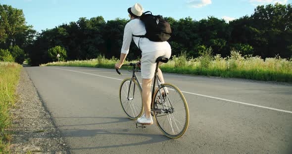 Backview of Male Riding Bike in Countryside