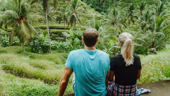Happy couple explore Tegalalang rice terraces near Ubud, Bali, Indonesia. Summer travel vocation
