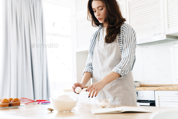 Image of thinking brunette woman preparing dough while cooking pie