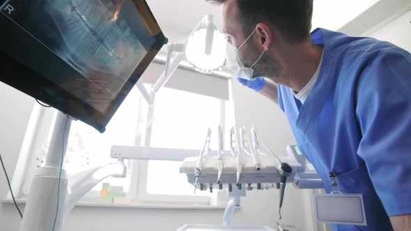 Male dentist setting the dental light alt