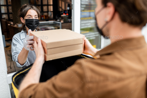 Courier taking an order for delivering from the shop window - Stock Photo - Images