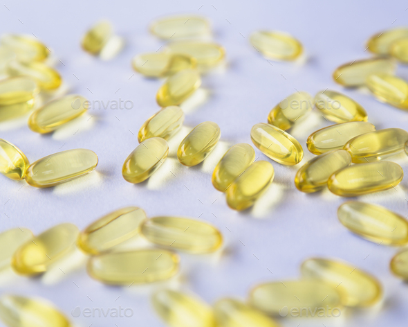 Fish oil providing Omega-3, in softgel supplement capsules. An essential fatty acid and health supplement product.