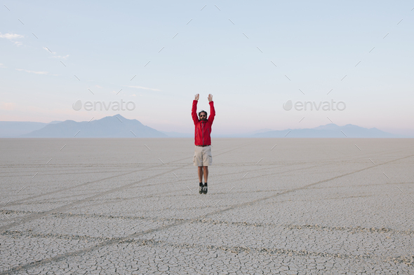 A man jumping in the air on the flat desert or playa or Black Rock Desert, Nevada.