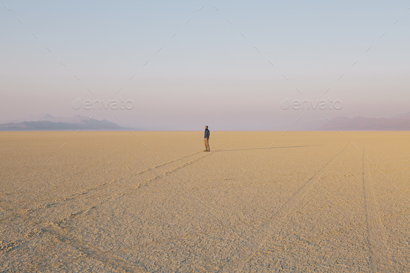 The figure of a man in the empty desert landscape of Black Rock desert, Nevada.