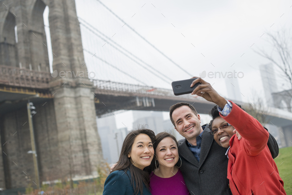 Four friends taking a picture with a phone,a selfy of themselves in