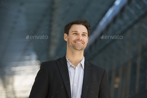 Business people in the city, A man in a black jacket and open collared shirt.