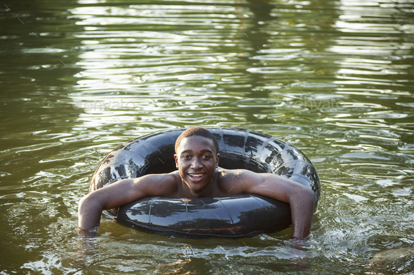 A boy floating in the water using a tyre swim float.
