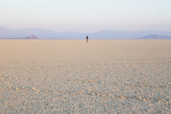 The figure of a man in the empty desert landscape of Black Rock desert, Nevada.