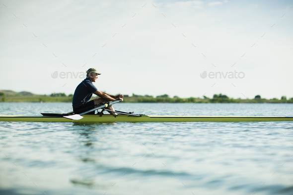 A middle-aged man in a rowing boat on the water.