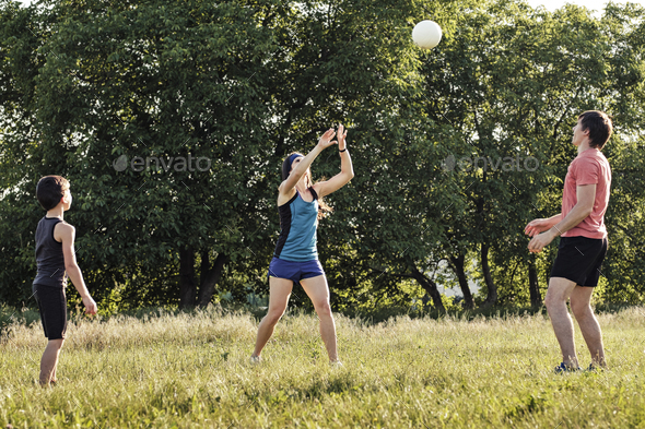 Young family having fun playing with a ball - Stock Photo - Images