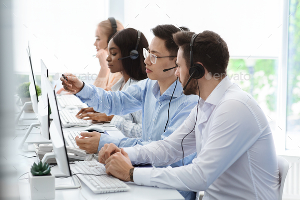 Customer support service. Hotline operator helping his colleague