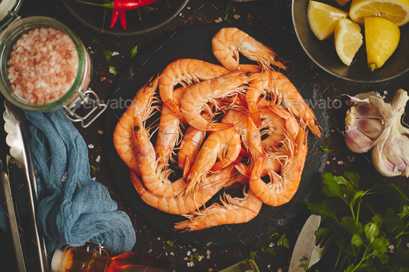 Raw fresh prawns with various ingredients such as lemon fresh herbs, garlic, chilli pepper - Stock Photo - Images