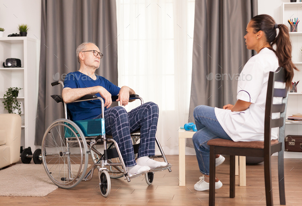 Person in wheelchair talking with nurse