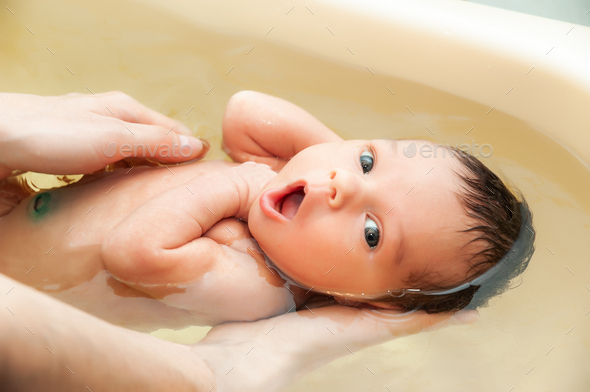 Little charming girl bathes in warm water Stock Photo by