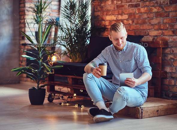 The full body image of blond stylish male using a tablet PC. - Stock Photo - Images