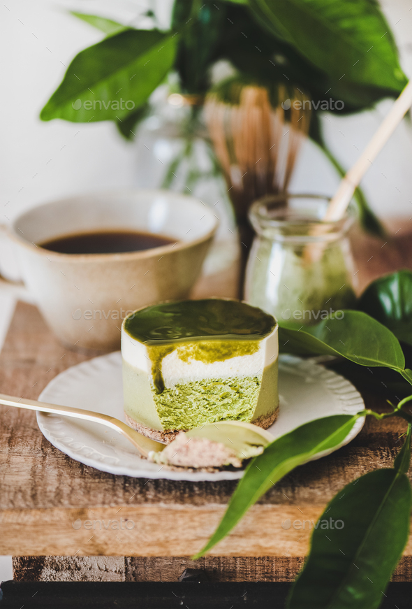 Green matcha cheesecake and coffee in mug on kitchen counter - Stock Photo - Images