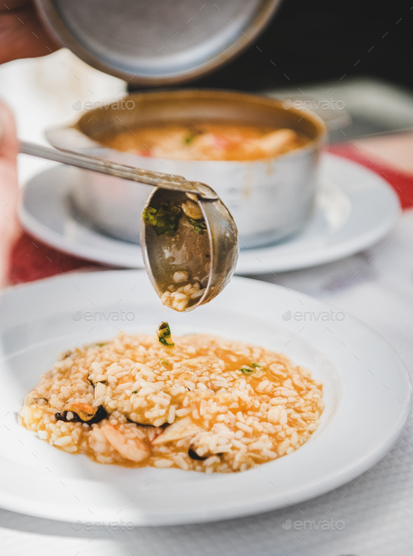 Plate with Portuguese traditional dish with seafood and rice - Stock Photo - Images