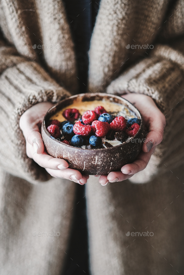 Healthy vegan breakfast bowl with oats in womans hands - Stock Photo - Images