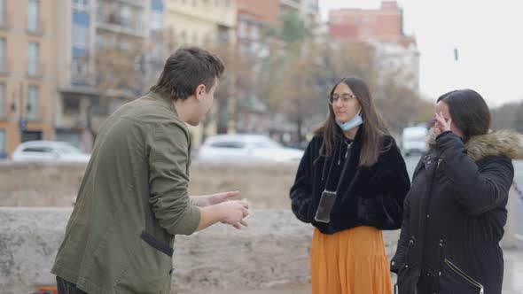 Side View of Magician Showing Magic Tricks to Unknown Person in the Street alt