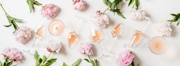Rose wine in glasses and blossom peonies over white background - Stock Photo - Images