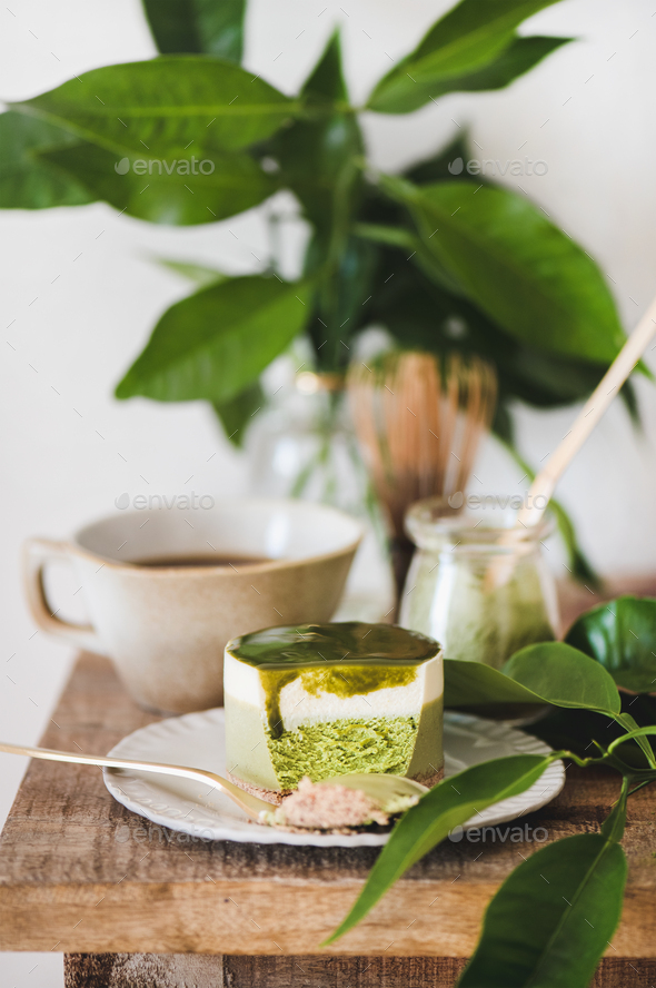 Green matcha cheesecake and black coffee on kitchen counter - Stock Photo - Images