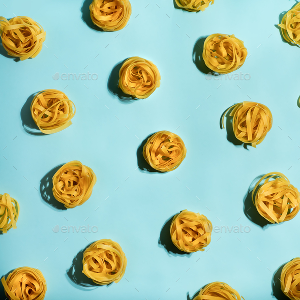 Pasta art with tagliatelle on blue background - Stock Photo - Images