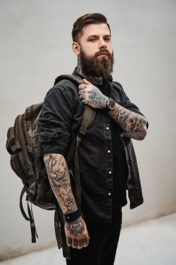Bearded hipster guy with backpack in a studio Stock Photo by fxquadro