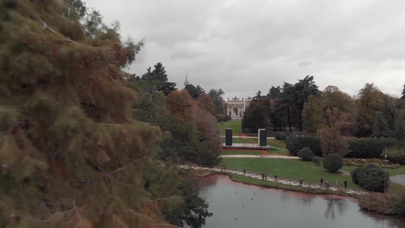 Drone passing trees in Sempione Park, Parco Sempione, Milan alt