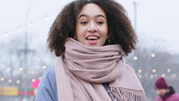 Portrait of Young Mixed Race Girl with Curly Hair in Outerwear with Pink Scarf Stands on Street in alt
